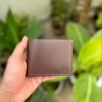 Handmade full grain brown pull up leather bifold wallet with same color saddle stitching and embossed logo