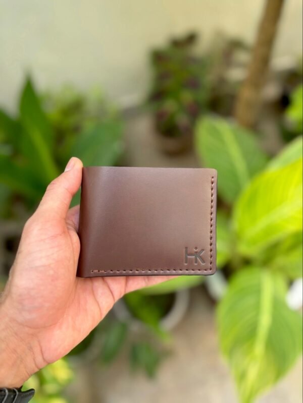 Handmade full grain brown pull up leather bifold wallet with same color saddle stitching and embossed logo