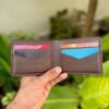 Open interior of brown full grain leather bifold wallet featuring V-cut card slots