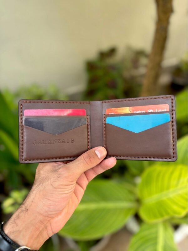 Open interior of brown full grain leather bifold wallet featuring V-cut card slots