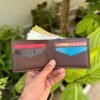 Open interior of brown full grain leather bifold wallet featuring V-cut card slots and cash compartment