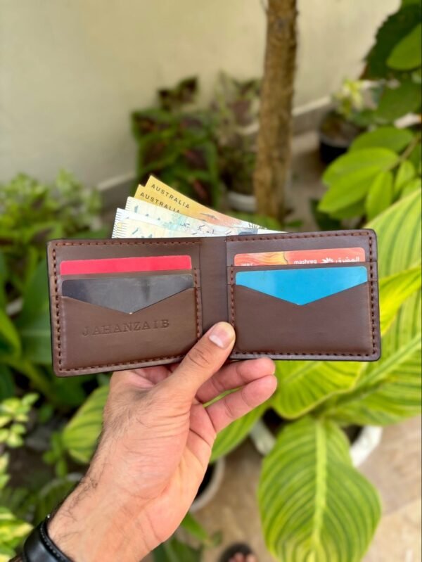 Open interior of brown full grain leather bifold wallet featuring V-cut card slots and cash compartment