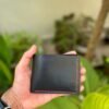 Handmade full grain black pull up leather bifold wallet with contrast red saddle stitching and embossed logo