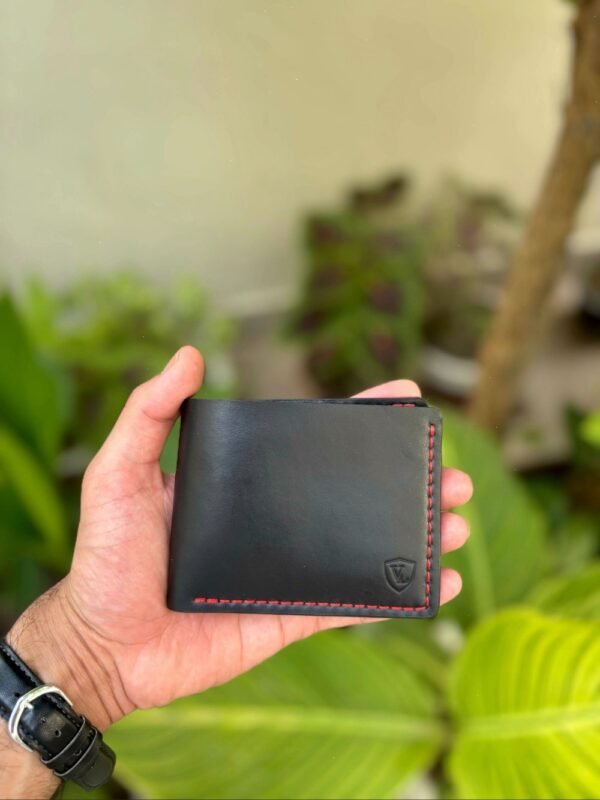 Handmade full grain black pull up leather bifold wallet with contrast red saddle stitching and embossed logo
