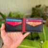 Open interior of black and red full grain leather bifold wallet featuring V-cut card slots and cash compartment