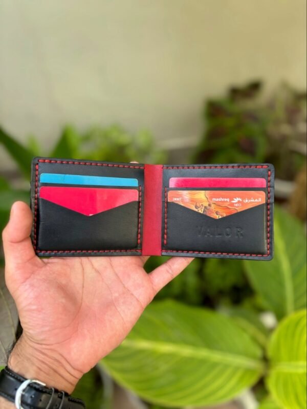 Open interior of black and red full grain leather bifold wallet featuring V-cut card slots and cash compartment